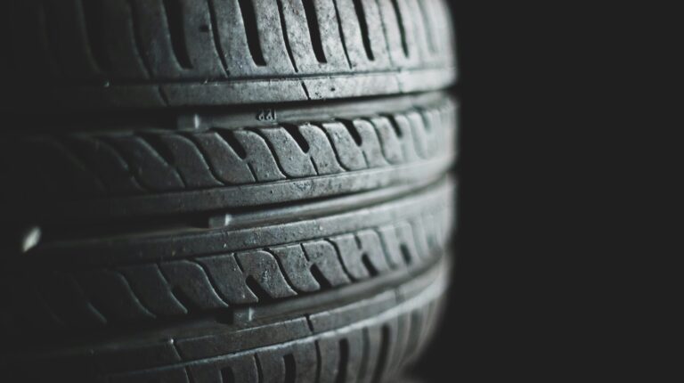Scientists call for deeper investigation and standardization for measuring and assessing tire wear emissions Stacked tires against a black background