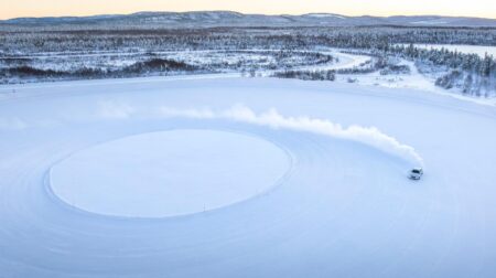 Car drifting on an outdoor tire testing facility.