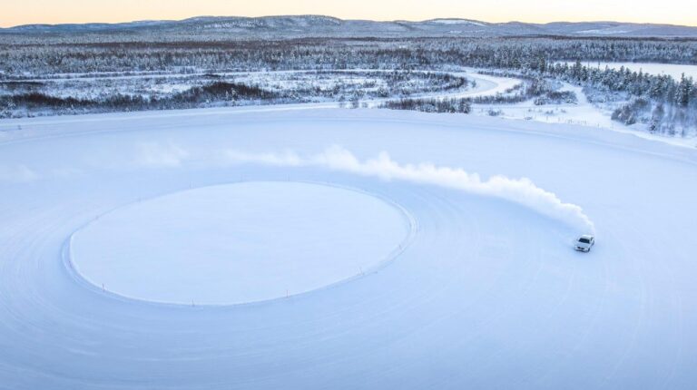 Car drifting on an outdoor tire testing facility.