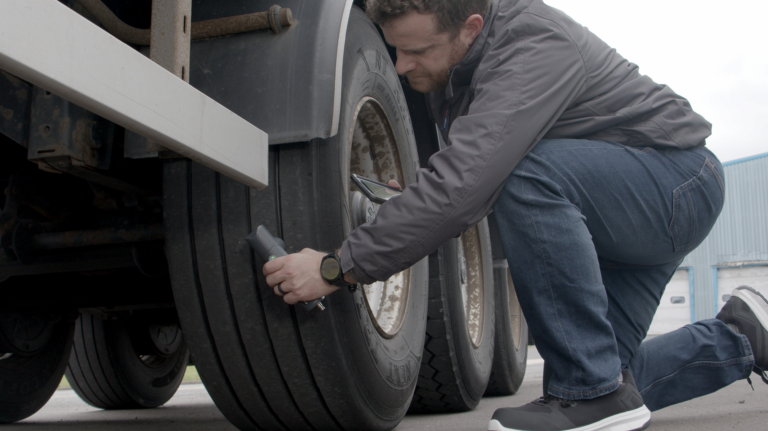 Transense Technologies managing director Ryan Maughan inspects a truck trailer tire with TLGX4.