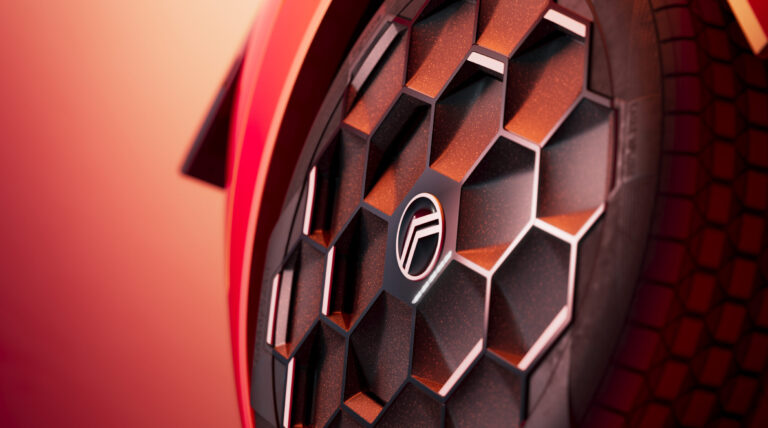 Close up of the Goodyear Eagle Xplore concept tire on a red Citroën ELO concept, with an orange-red background
