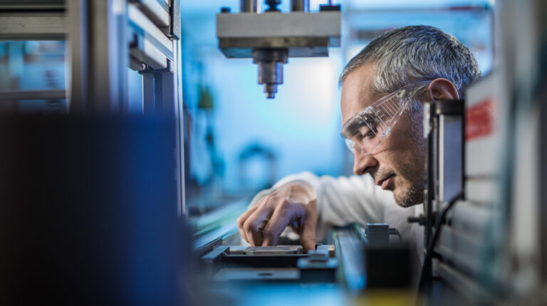 OPINION: Harmonization is the superpower tire emissions research needs now A scientist wearing safety glasses and a white lab coat looks at a sample on a table