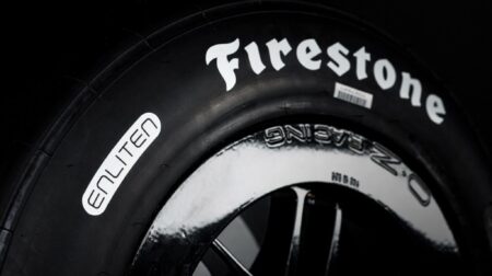 Firestone unveils sustainable Enliten Firehawk tires for 2026 IndyCar season A black tire with Firestone and Enliten written along the sidewall in white.