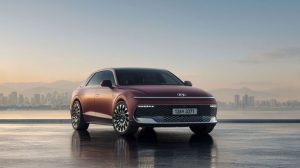 The Hyundai New Grandeur SUV parked on a rooftop in front of a city background.