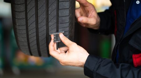 Fraunhofer TERIS tire abrasion analysis project reaches milestone A man runs a piece of testing equipment along the side of a tire.