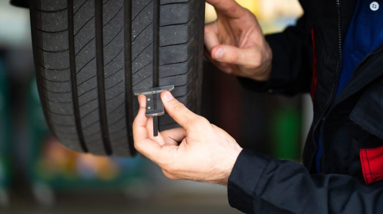 Fraunhofer TERIS tire abrasion analysis project reaches milestone A man runs a piece of testing equipment along the side of a tire.